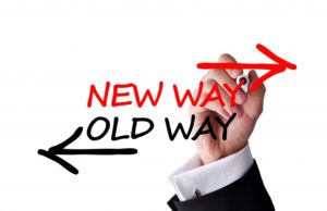A man writing on the wall with words " new way " and " old way ".